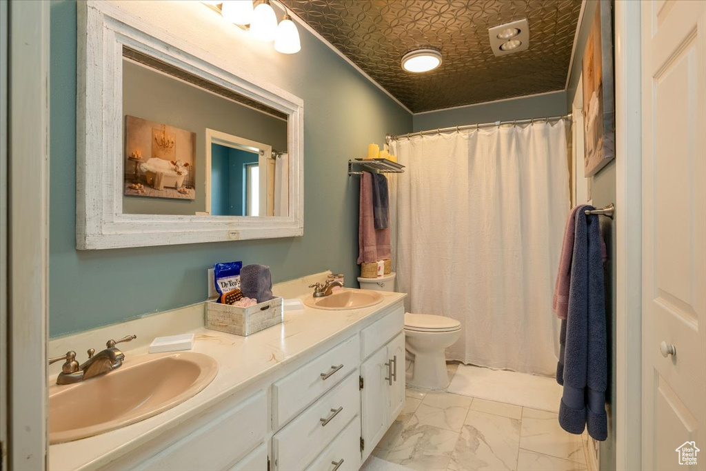 Bathroom featuring double vanity, marble look tile flooring, a shower with shower curtain, and an ornate ceiling