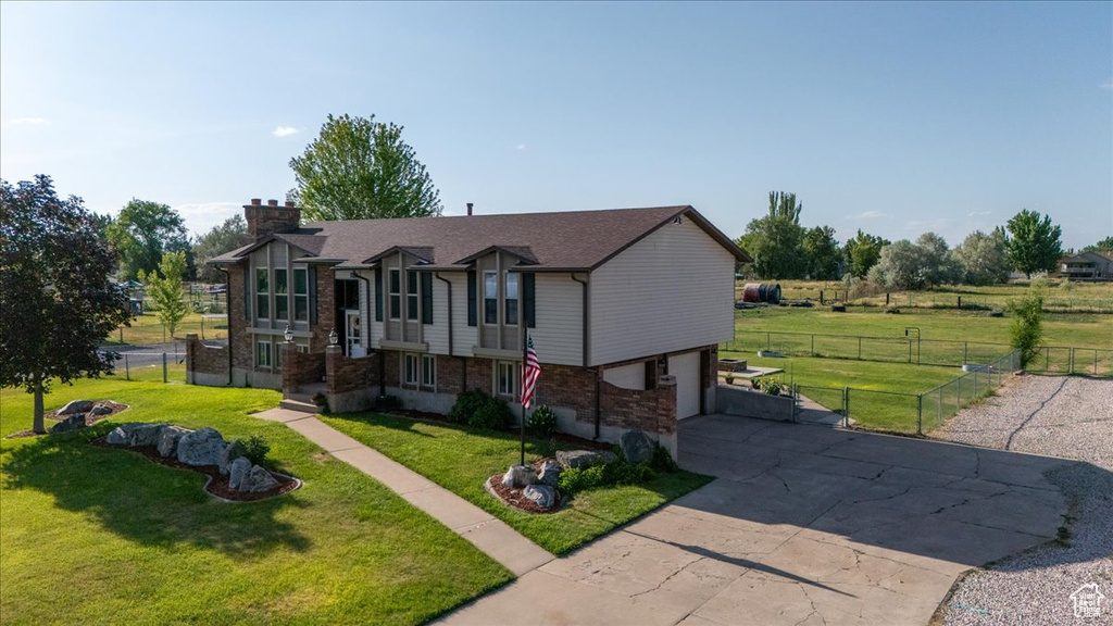 View of front of house featuring concrete driveway, a chimney, a garage, and brick siding