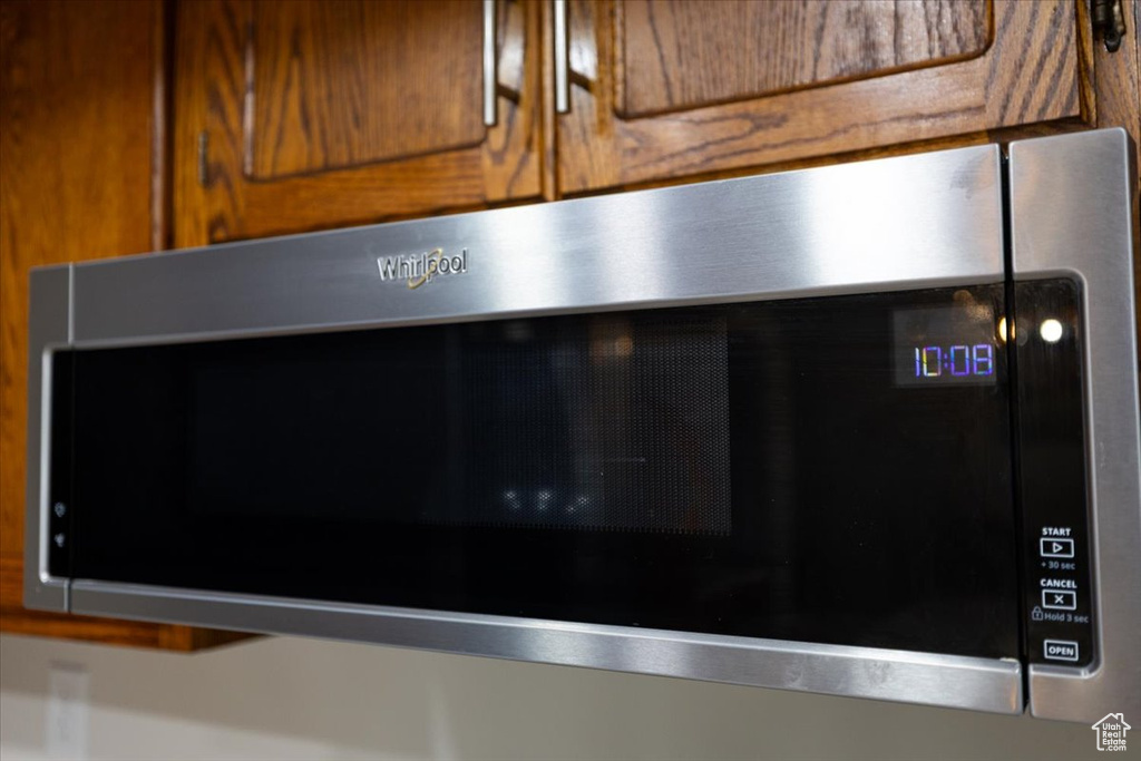 Detailed view of stainless steel microwave and brown cabinetry