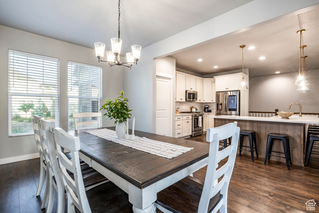 Dining room featuring dark wood-type flooring, a chandelier, and recessed lighting
