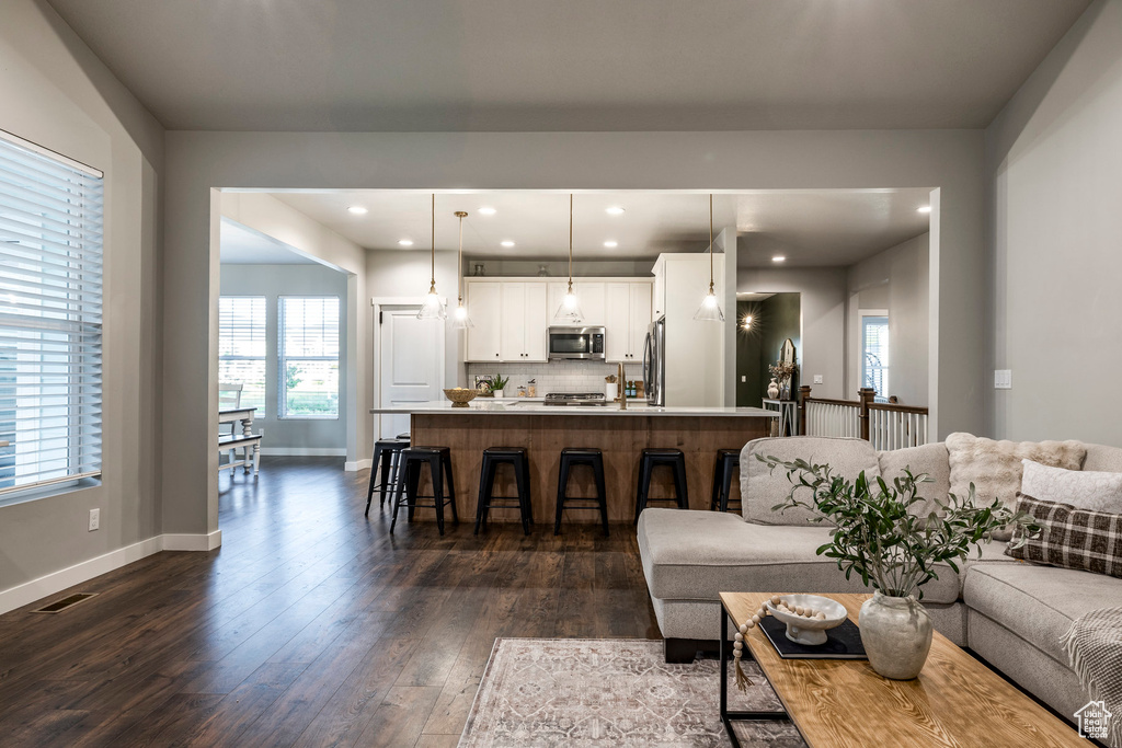Living area with dark wood-style flooring and recessed lighting