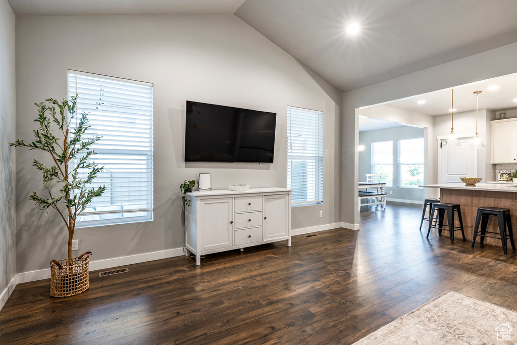 Living area with dark wood-type flooring, lofted ceiling, and recessed lighting