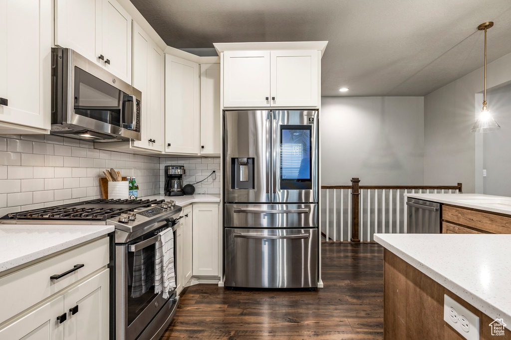 Kitchen with stainless steel appliances, dark wood-style floors, backsplash, and recessed lighting