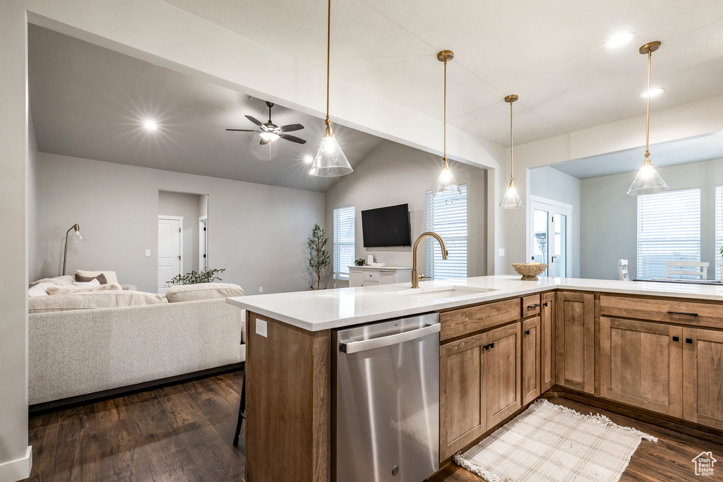 Kitchen with stainless steel dishwasher, open floor plan, dark wood-type flooring, light countertops, and plenty of natural light