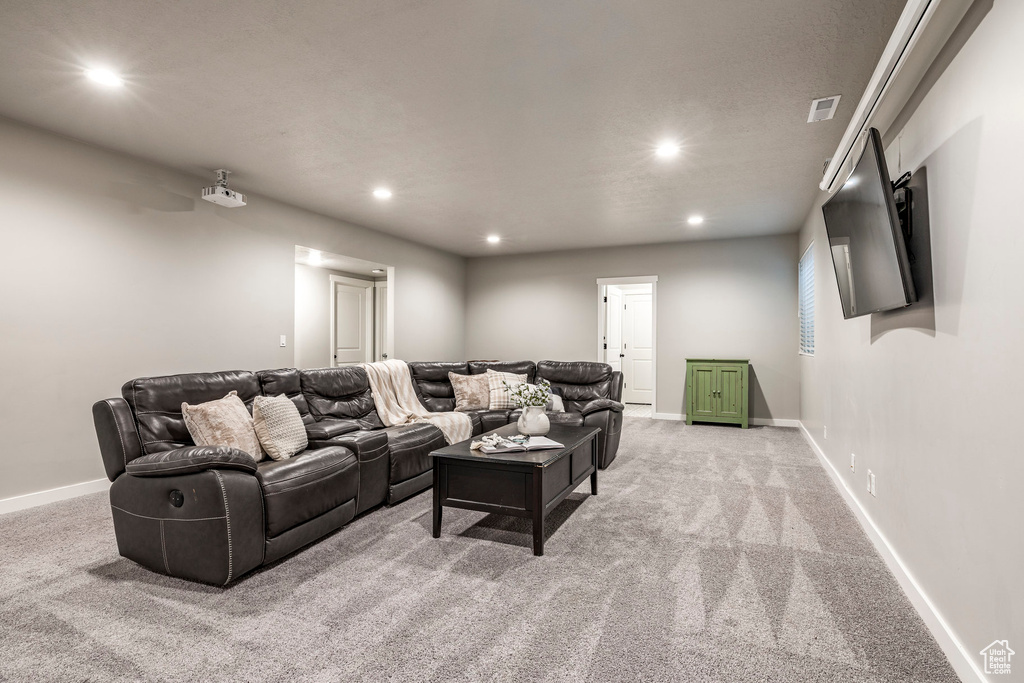 Living area with light colored carpet and recessed lighting