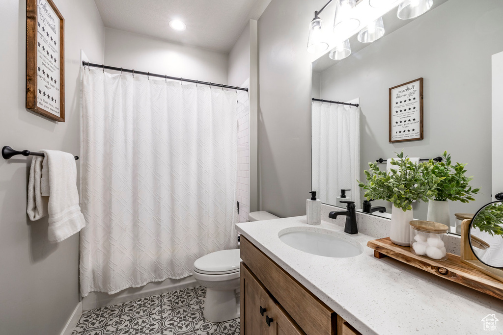 Bathroom with vanity, tile patterned flooring, shower / bath combo with shower curtain, and recessed lighting