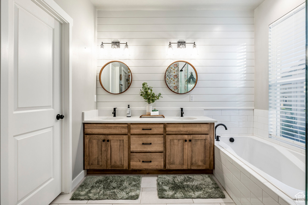Full bath featuring tile patterned flooring, double vanity, and a garden tub