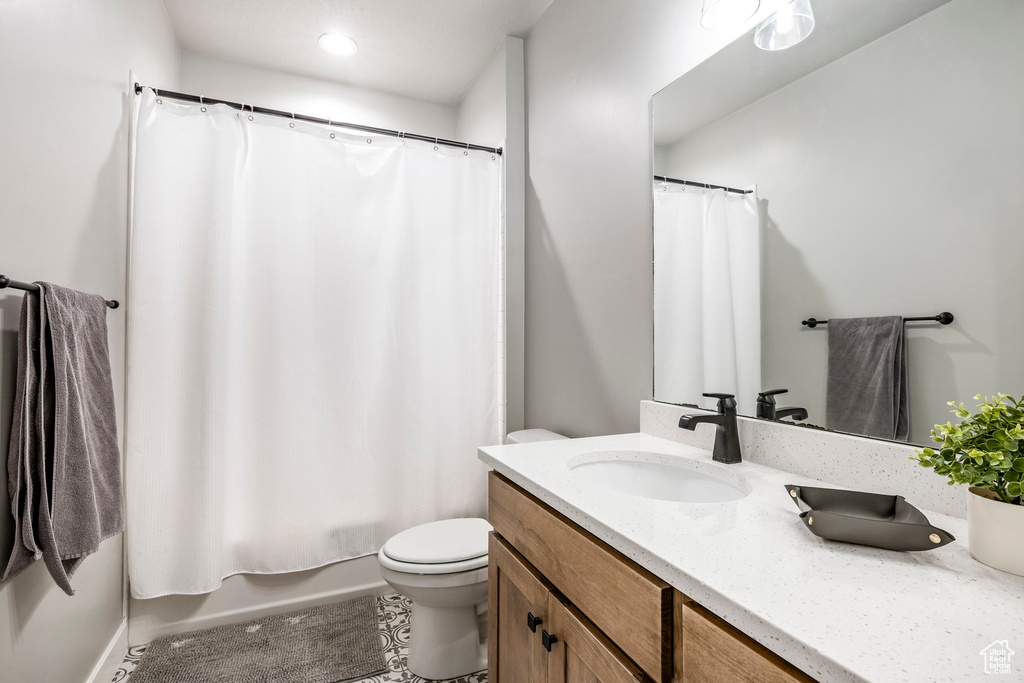 Full bathroom with vanity, shower / bath combo with shower curtain, tile patterned flooring, and recessed lighting