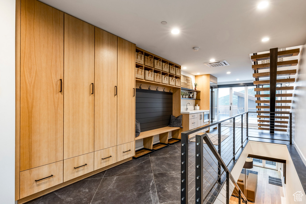 Living area with recessed lighting and dark marble finish floors