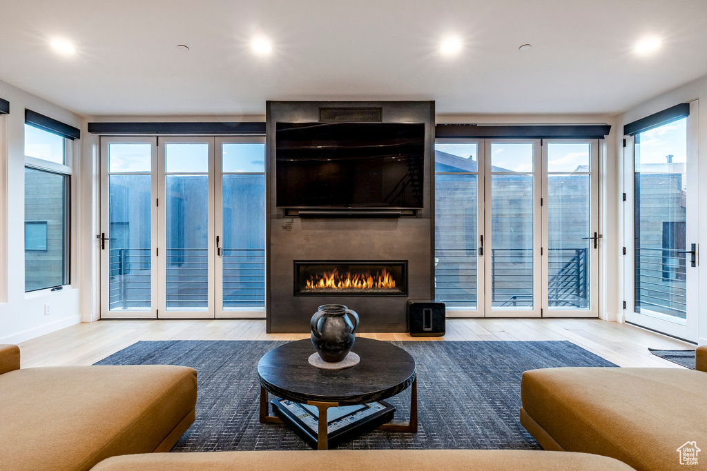 Living room featuring wood finished floors, a large fireplace, and recessed lighting
