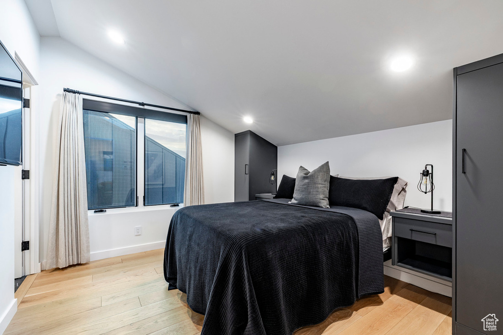 Bedroom featuring lofted ceiling, light wood finished floors, and recessed lighting
