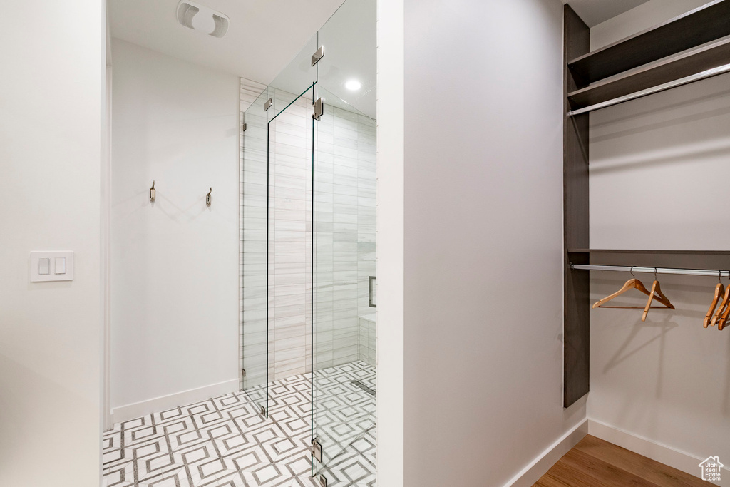 Full bathroom with a shower stall and a spacious closet