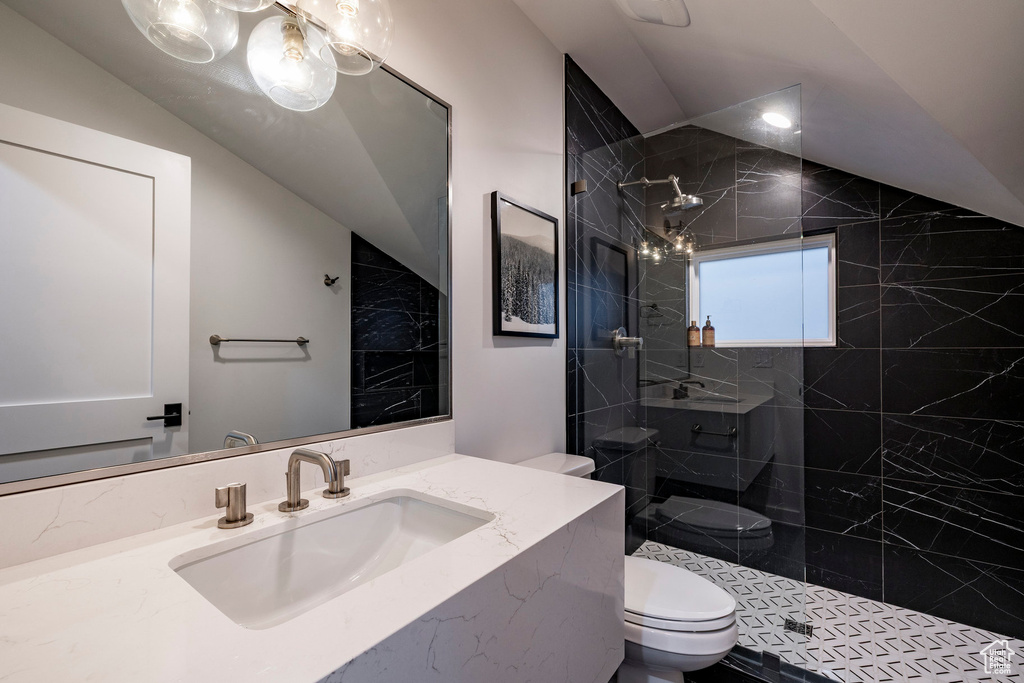 Full bath with a walk in shower, vanity, and vaulted ceiling