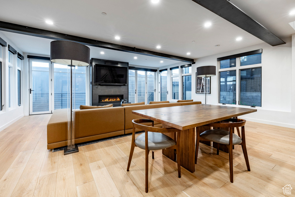 Dining room featuring a large fireplace, light wood-style floors, beam ceiling, and recessed lighting