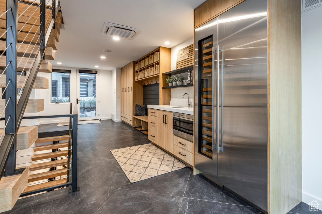 Kitchen with open shelves, modern cabinets, recessed lighting, light countertops, and light brown cabinetry