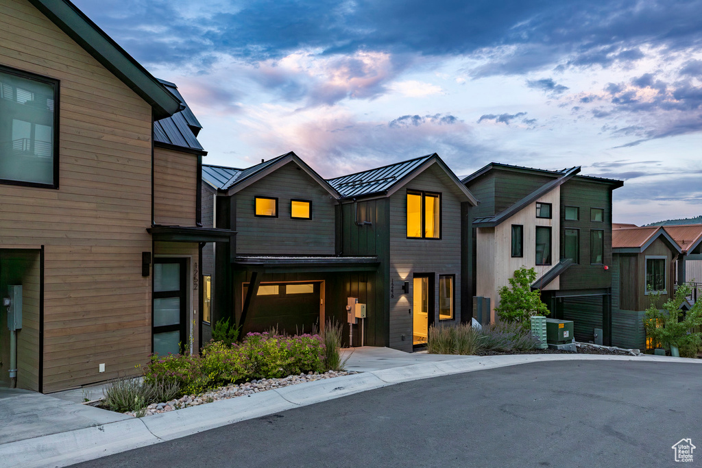 Modern home with a standing seam roof, a metal roof, and a garage