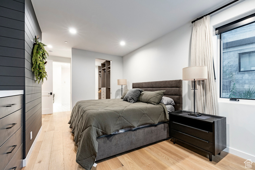 Bedroom featuring light wood-type flooring, recessed lighting, and a spacious closet