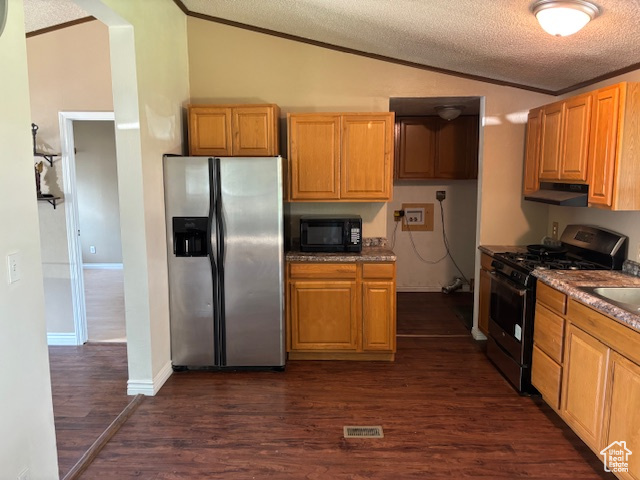 Kitchen with stainless steel fridge, gas range, lofted ceiling, black microwave, and ornamental molding