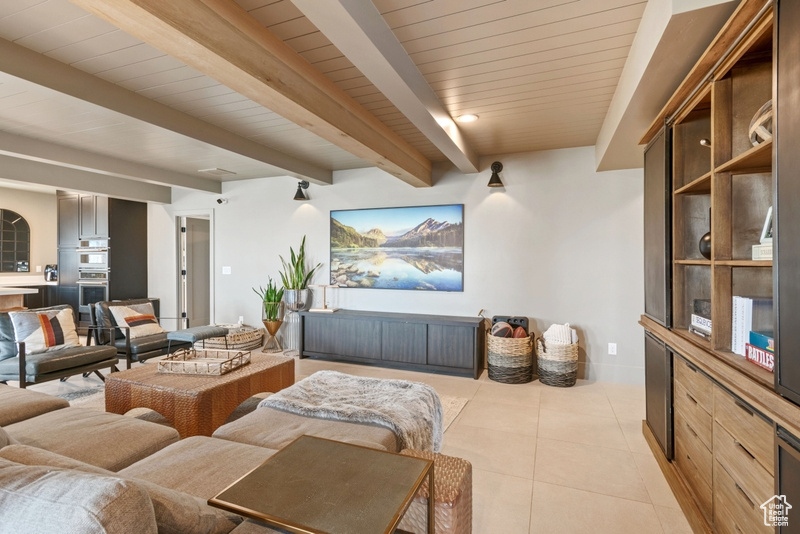Living room featuring beam ceiling and light tile patterned floors