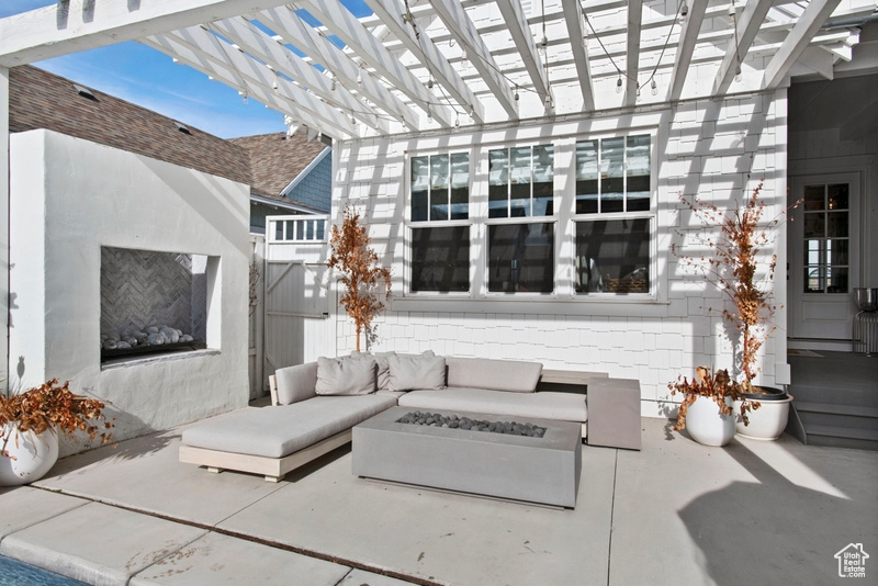 View of patio with an outdoor living space with a fire pit and a pergola