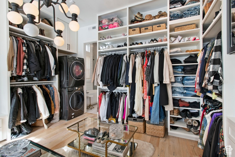 Spacious closet featuring stacked washer / dryer and wood finished floors