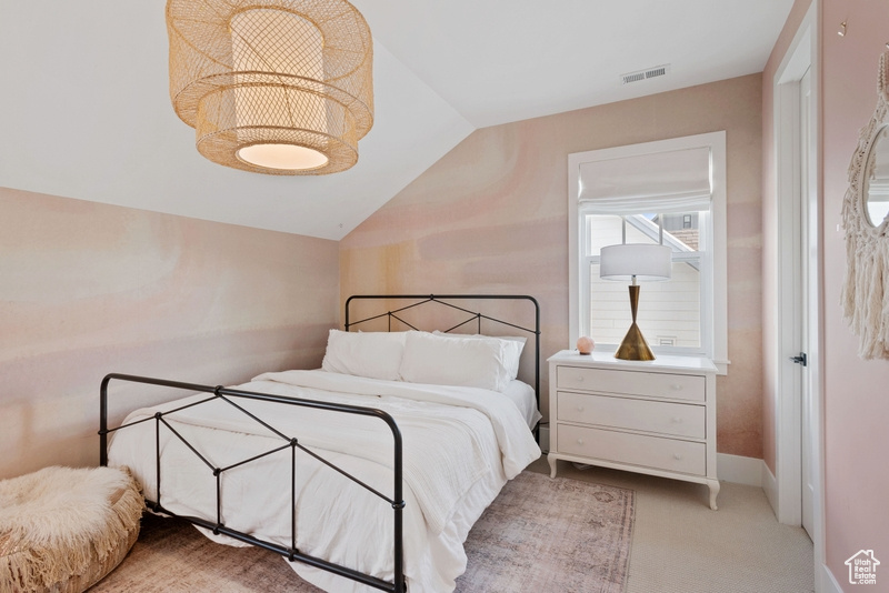 Bedroom featuring vaulted ceiling and light carpet