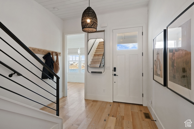 Foyer entrance with stairway and light wood-style floors