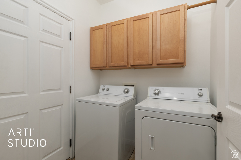 Washroom featuring separate washer and dryer and cabinet space