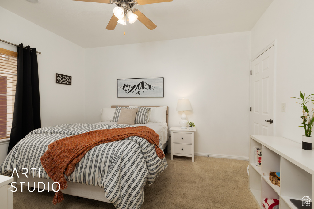 Carpeted bedroom with a ceiling fan and baseboards