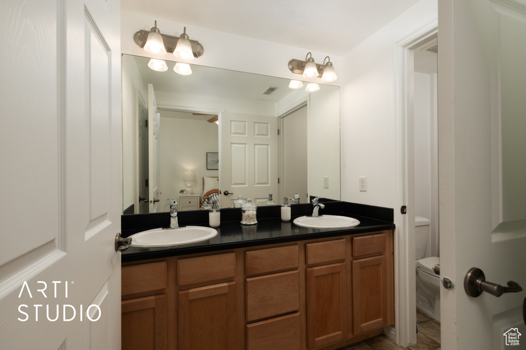 Bathroom featuring double vanity and toilet