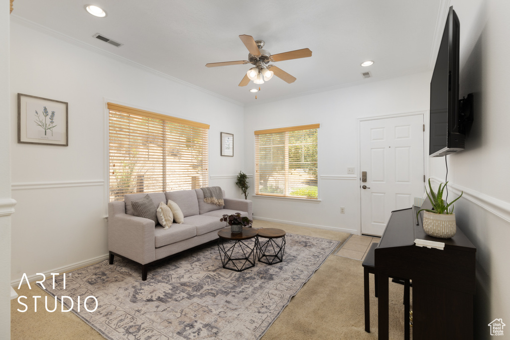 Carpeted living room with ceiling fan, recessed lighting, and crown molding