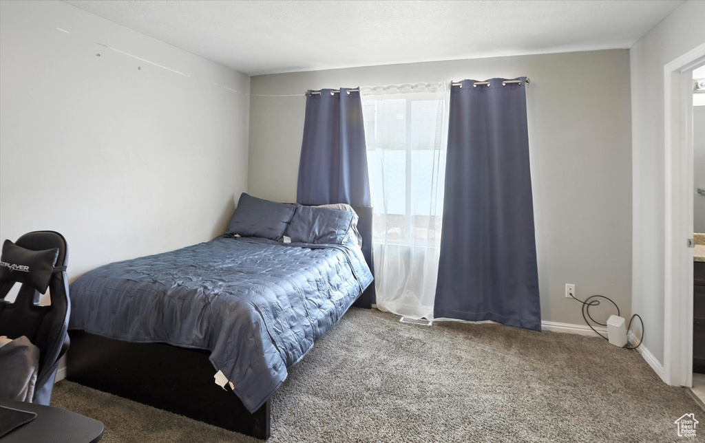 Bedroom featuring carpet and baseboards