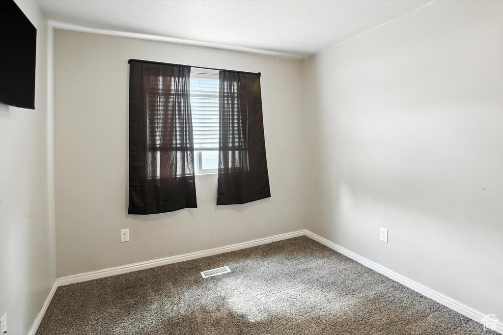 Carpeted empty room with baseboards