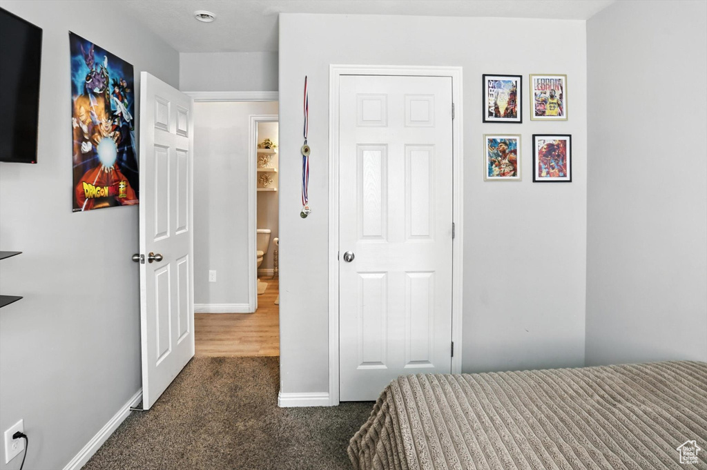 Bedroom with dark carpet and baseboards