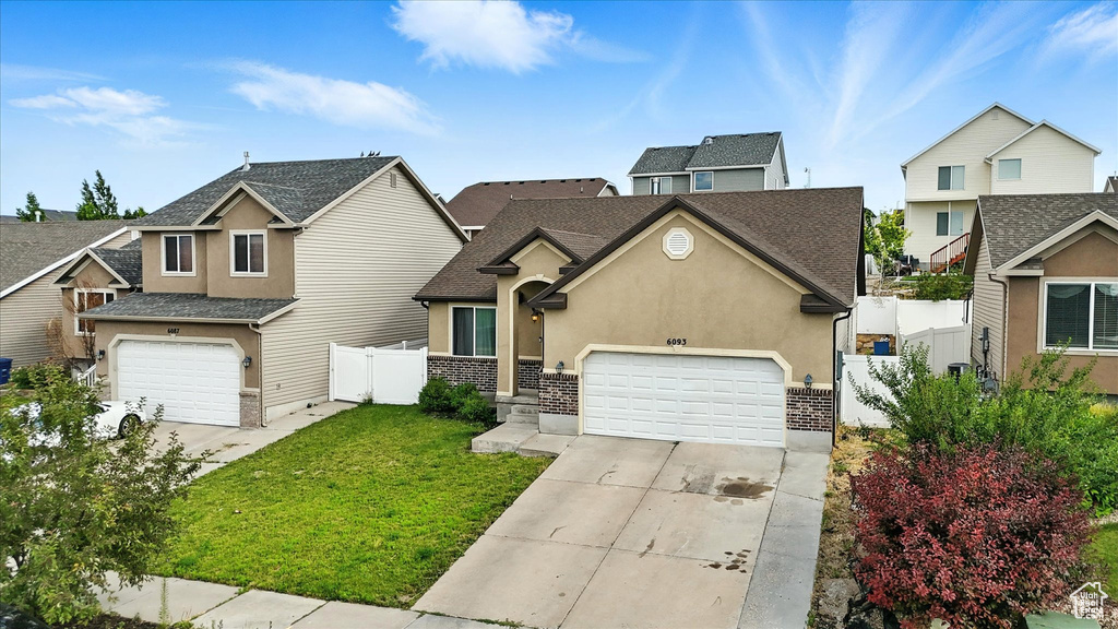 Traditional-style home with concrete driveway, stucco siding, a garage, and roof with shingles
