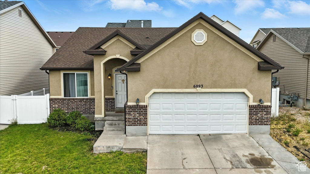 View of front of house featuring brick siding, stucco siding, driveway, a garage, and a shingled roof