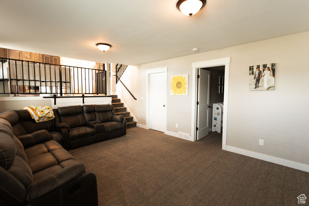 Living room featuring carpet and stairs