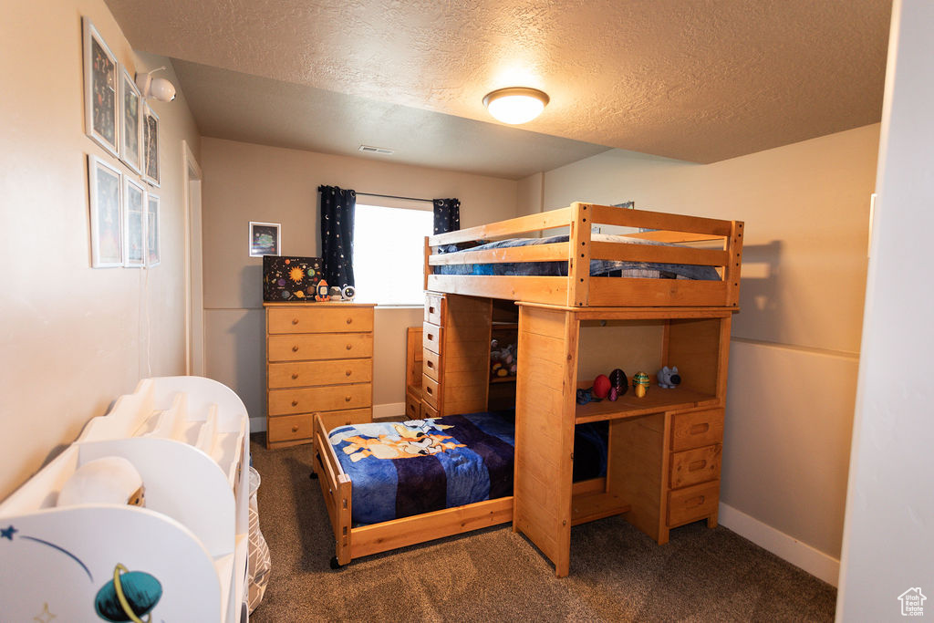 Bedroom featuring carpet flooring and a textured ceiling