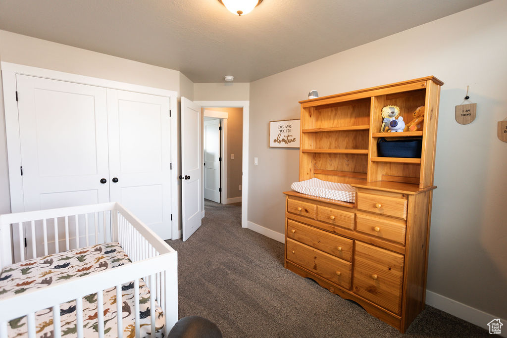 Bedroom with dark carpet and a closet
