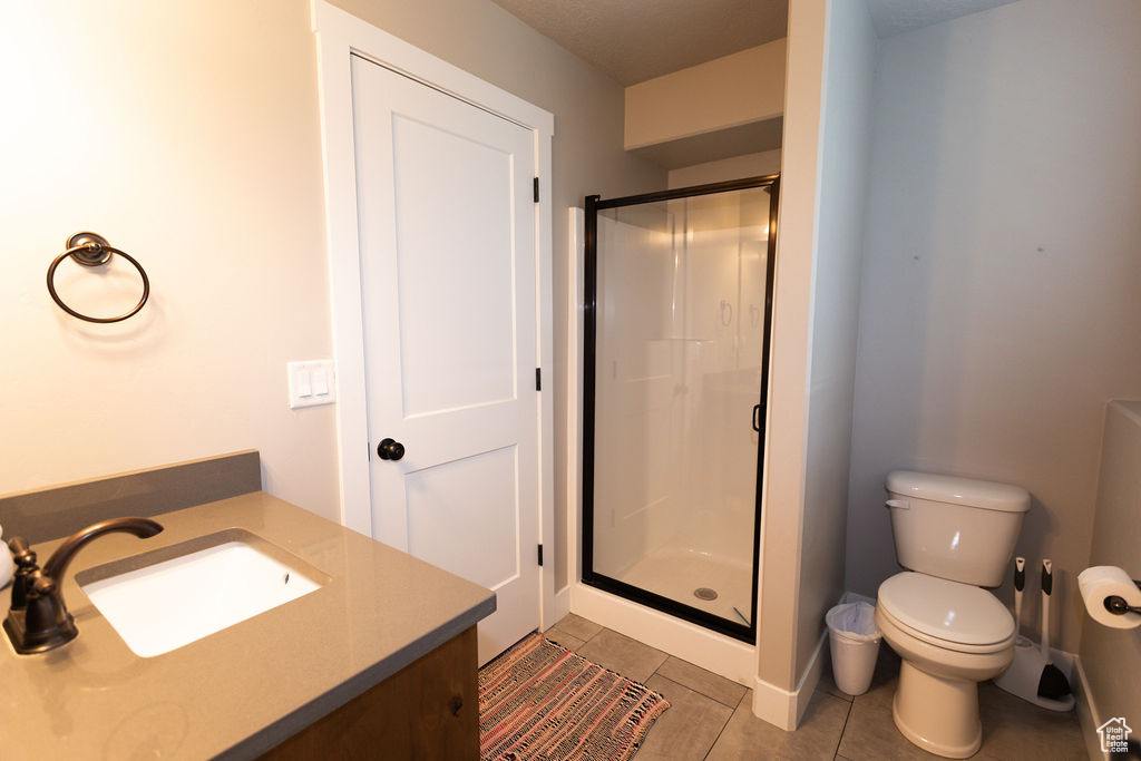 Full bath featuring a shower stall, vanity, and tile patterned flooring