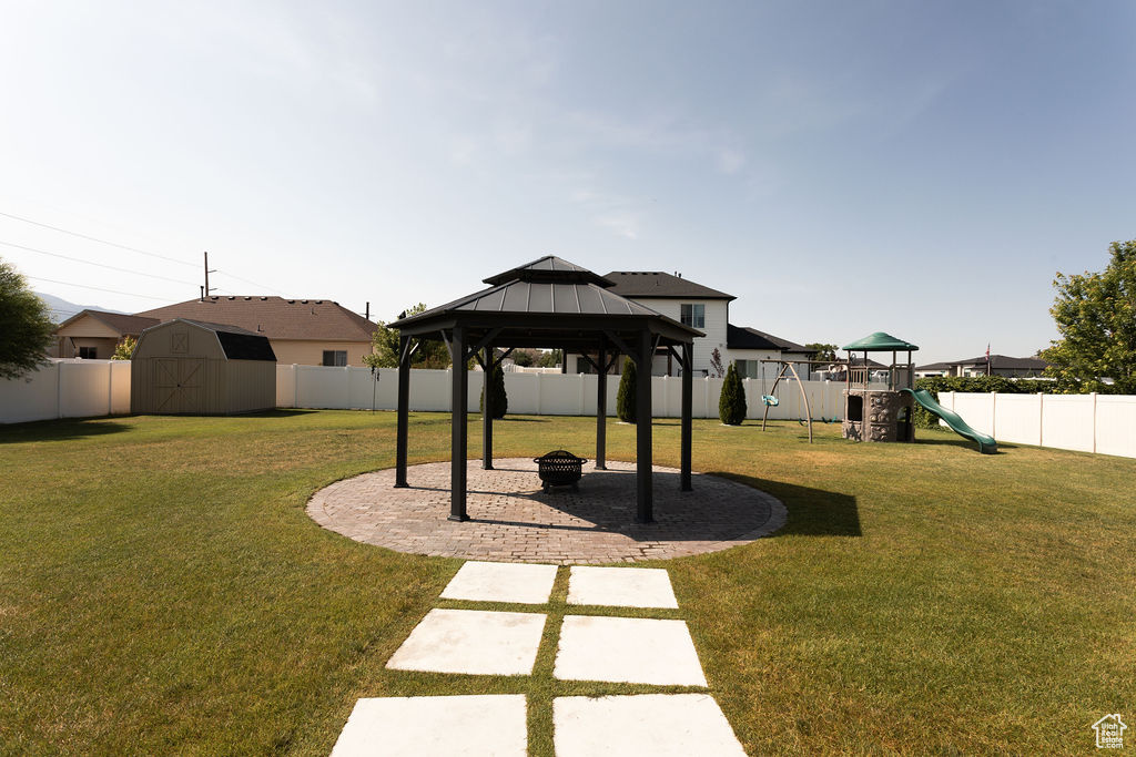 Fenced backyard with a shed, a gazebo, and a patio area