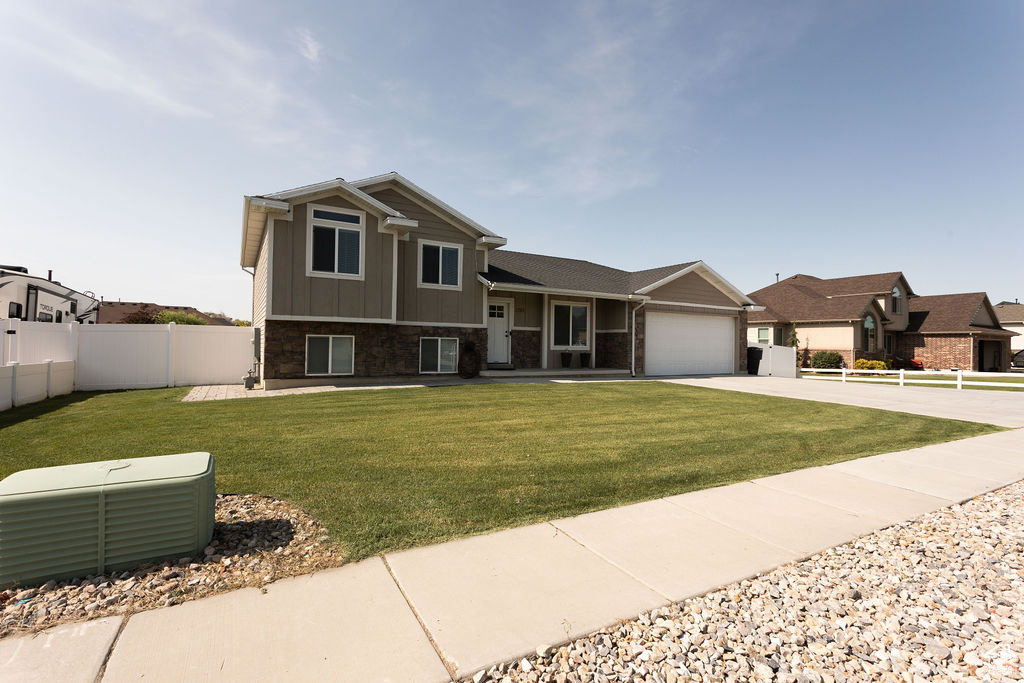 View of front of house featuring driveway, board and batten siding, a garage, and stone siding