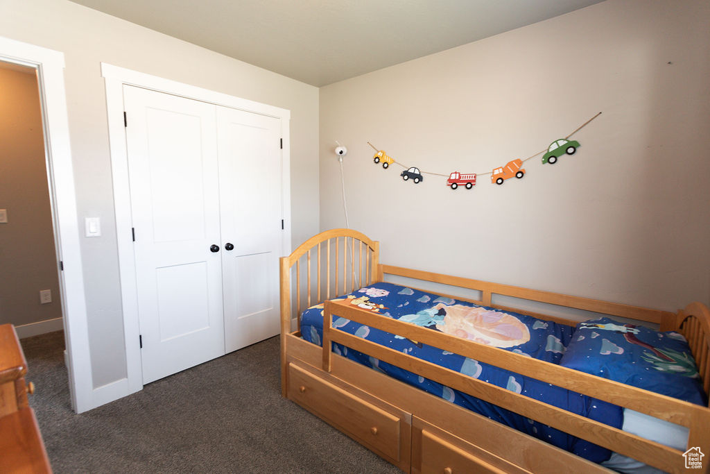 Carpeted bedroom featuring a closet and baseboards