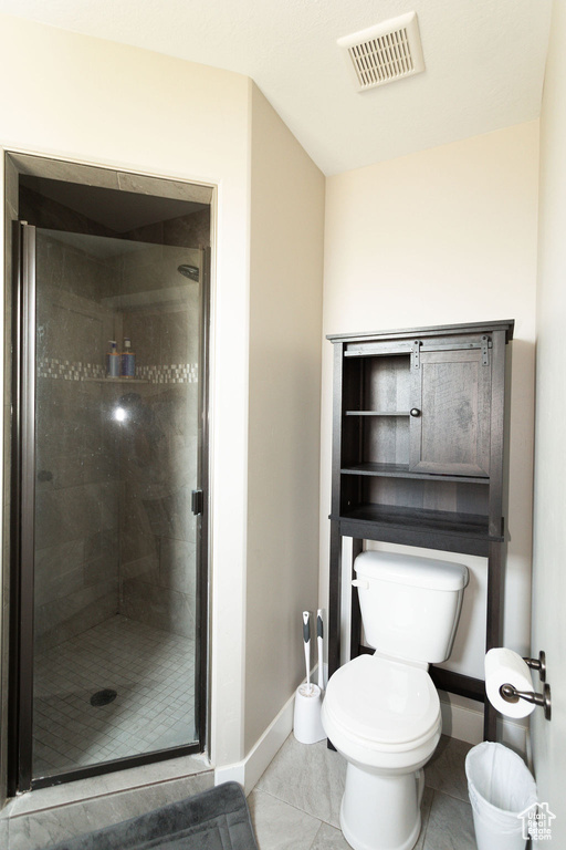 Full bathroom featuring a stall shower and tile patterned flooring