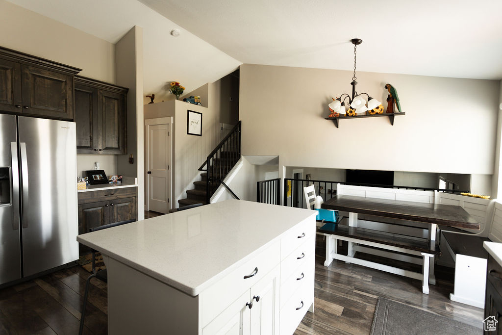 Kitchen featuring stainless steel fridge with ice dispenser, a chandelier, dark wood-style flooring, dark brown cabinets, and light countertops