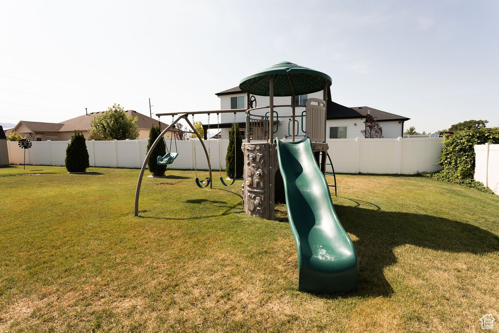View of play area with a fenced backyard
