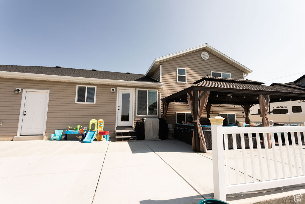 Rear view of property featuring a gazebo, a patio area, and entry steps