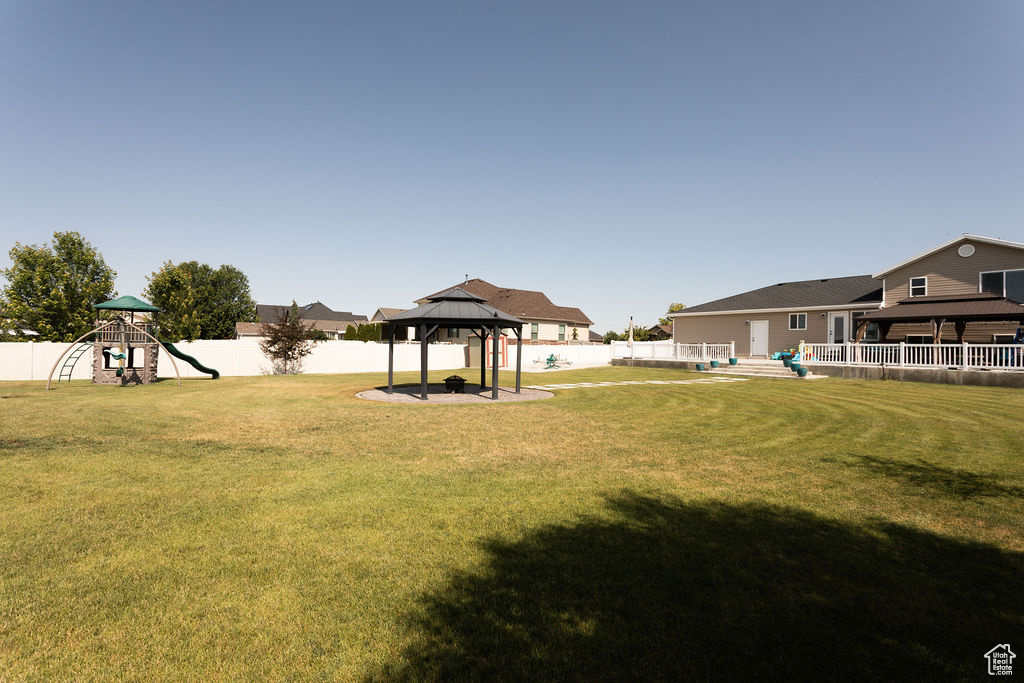 Fenced backyard with a gazebo and a playground