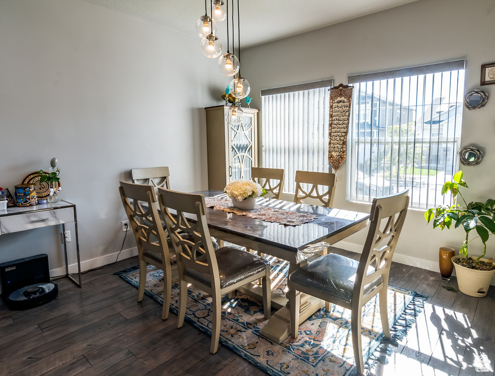 Dining room featuring dark wood-style floors and baseboards