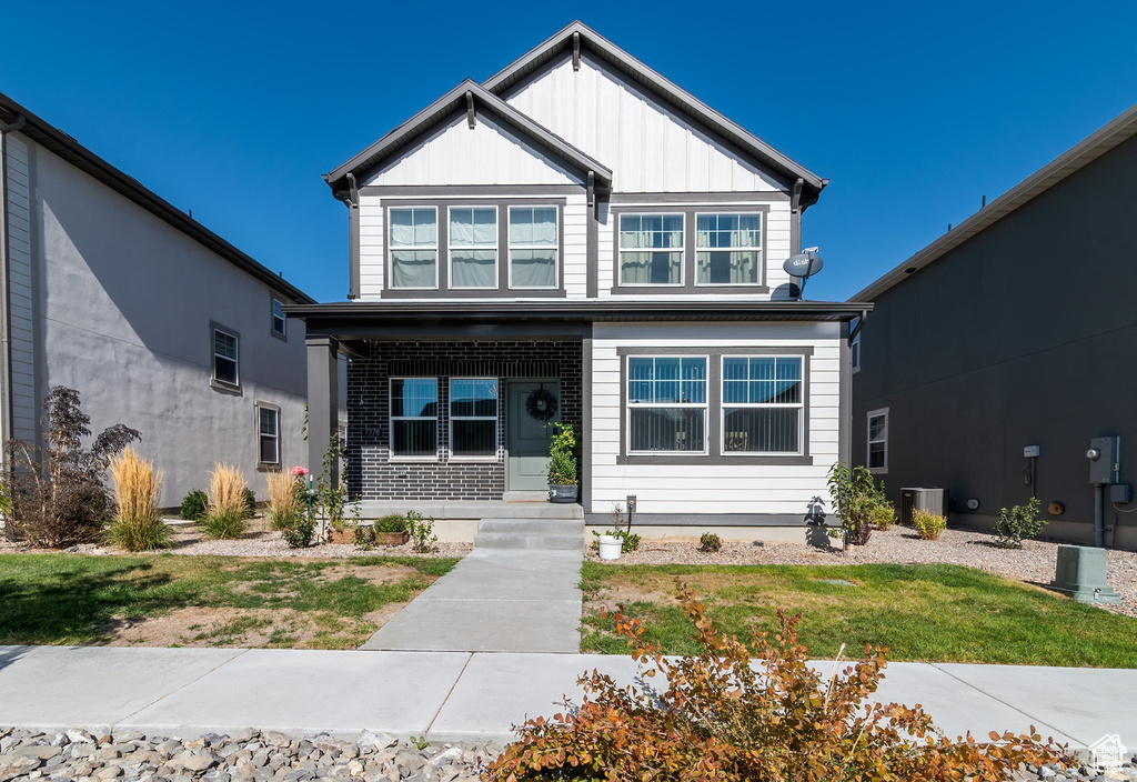 View of front of house featuring board and batten siding and a front lawn